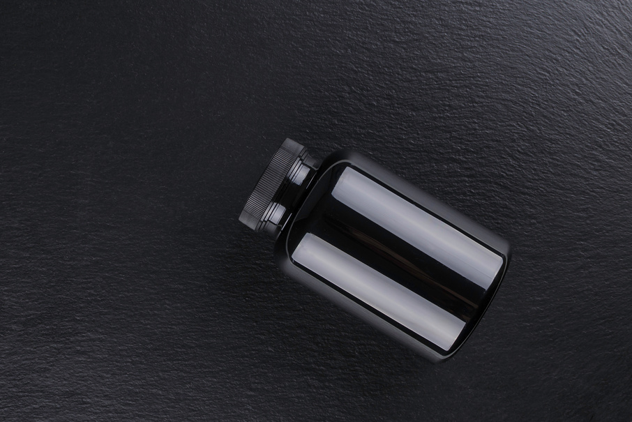 black medicine bottle mockup on black background